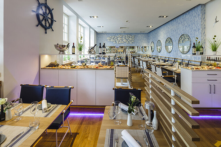 Bright hotel restaurant with fish buffet, modern design and maritime details