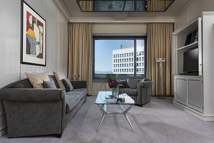 Spacious Executive Suite at Maritim Hotel Frankfurt with elegant decor, cozy seating area, and panoramic window.