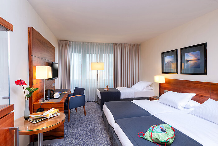 Family room with double and single bed for up to three people at the Maritim Hotel München.