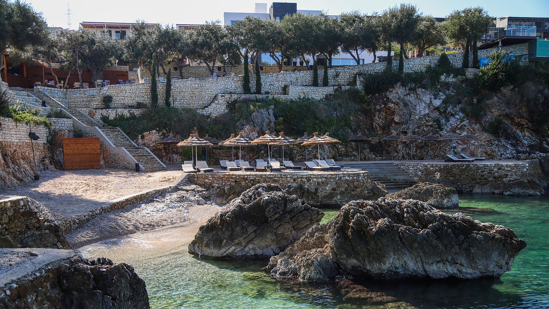 Private beach cove at Maritim Resort Marina Bay with loungers, rocks and clear turquoise water