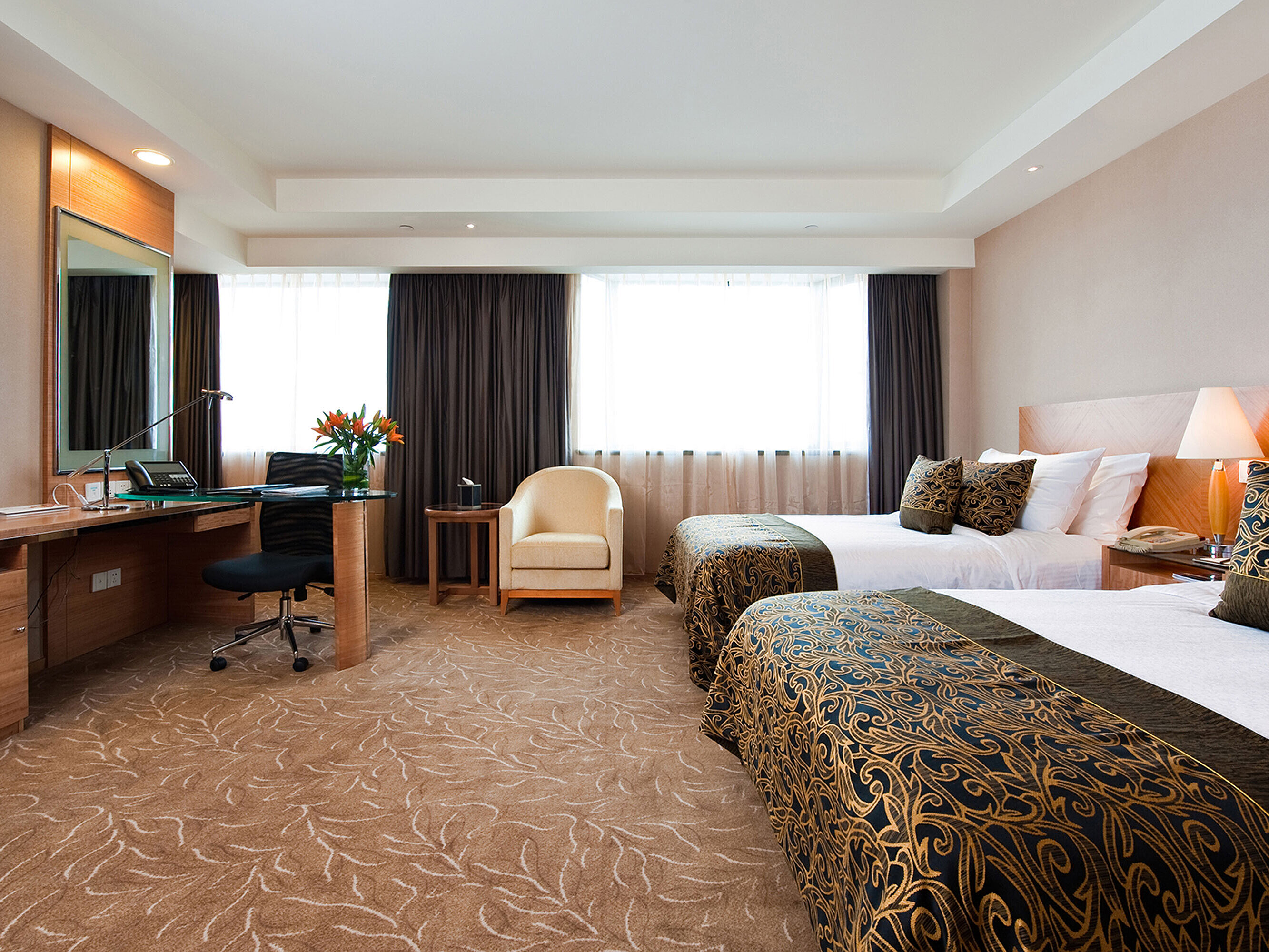 現代化酒店客房配備兩張床鋪、寬敞書桌、舒適扶手椅及充足自然光線，為您提供舒適的住宿體驗