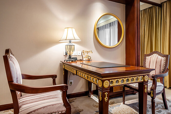 典雅經典風格的工作空間，配備木質書桌、軟墊座椅、檯燈及圓形鏡子