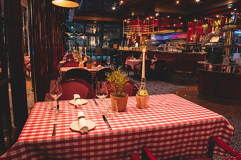 Cosy restaurant table with candle and red checkered pattern in the evening