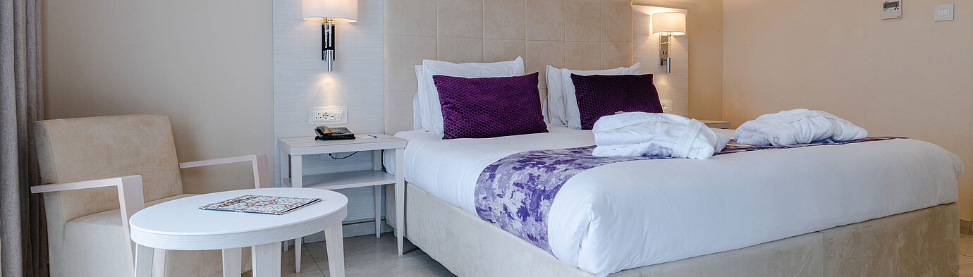 Elegant double room with seating area, bedside tables and warm lighting