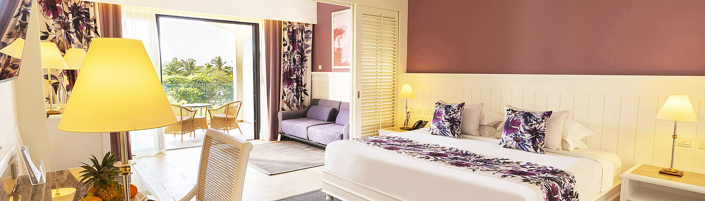 Room with a king-size bed, stylish furniture, and access to the terrace with a sea view