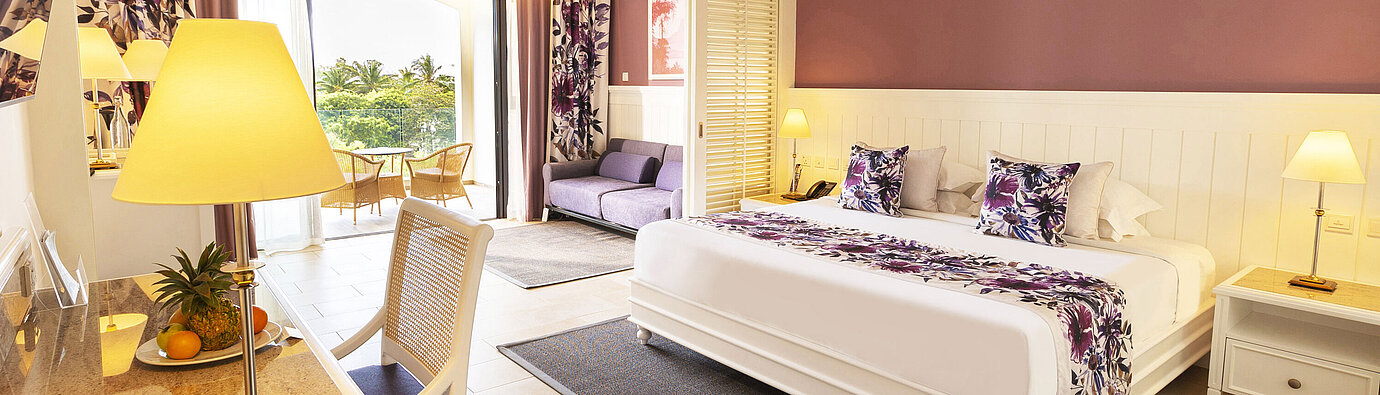 Room with a king-size bed, stylish furniture, and access to the terrace with a sea view