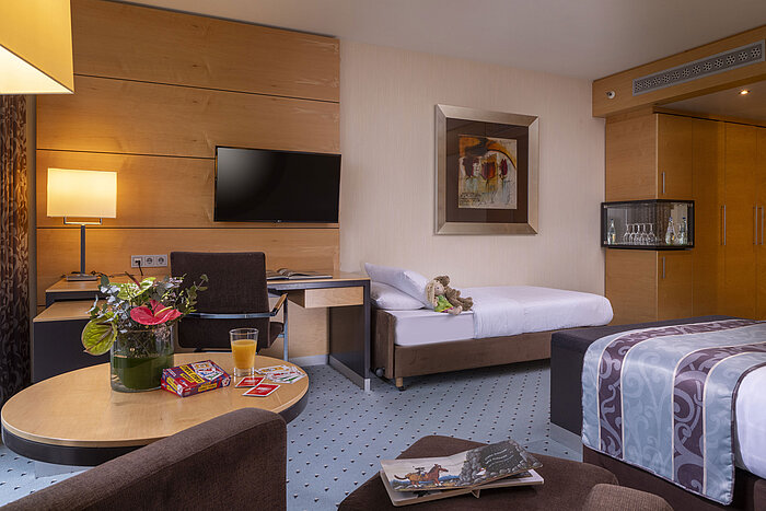 Comfortable family room at Maritim Hotel Düsseldorf with modern design and extra bed for children.