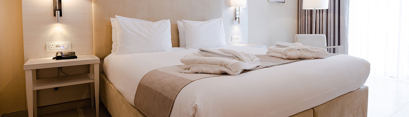 Modern double room with king-size bed, bedside tables and warm lighting