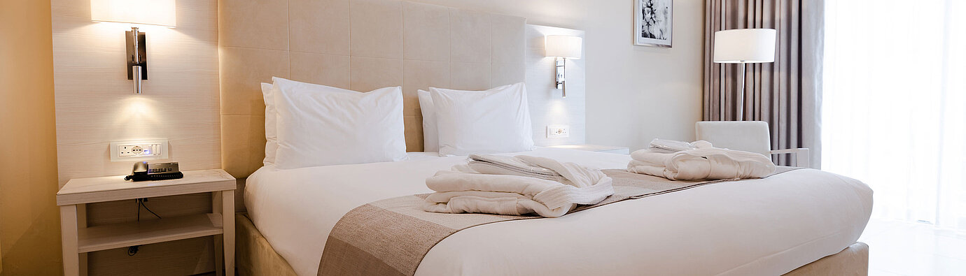 Modern double room with king-size bed, bedside tables and warm lighting