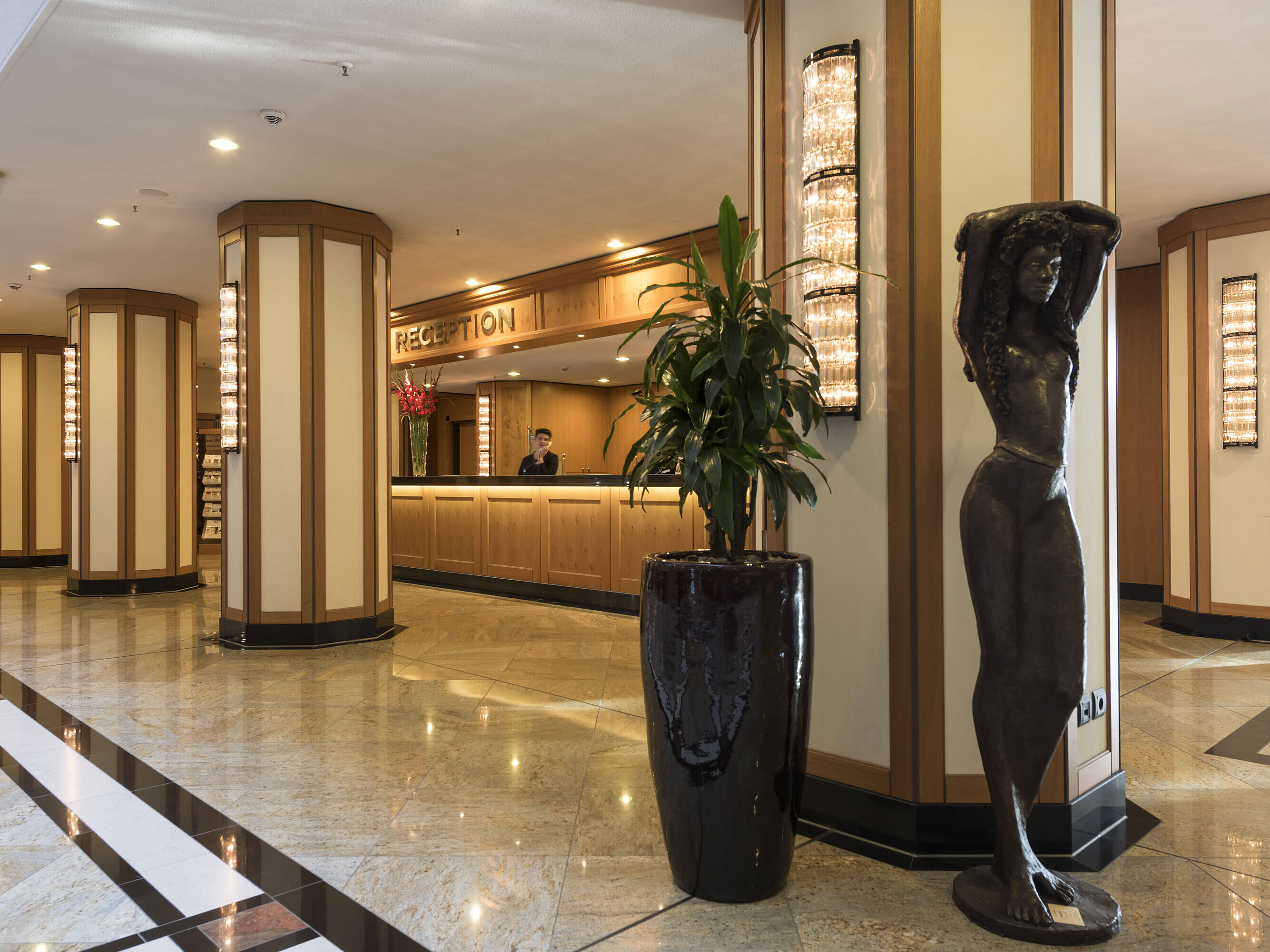 Elegant reception area of Maritim Hotel Dresden with sculpture and modern lighting.