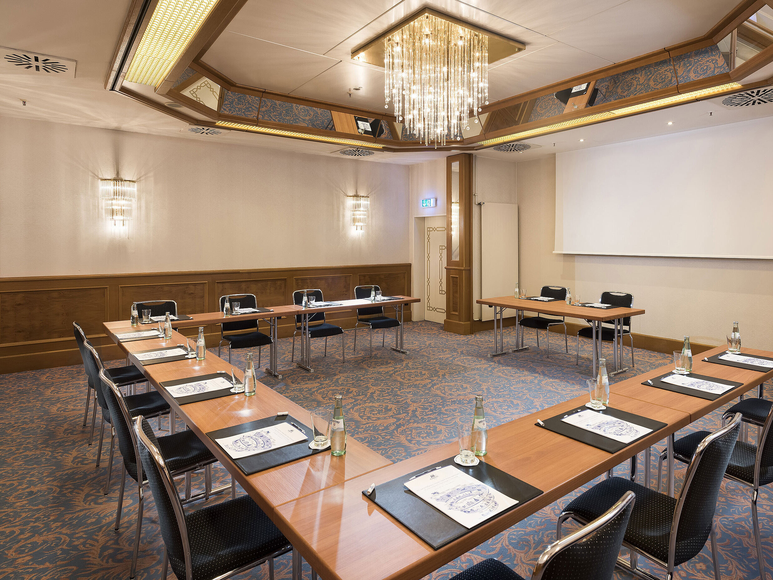 Bright conference room with U-shape seating and chandelier at the Maritim Hotel Munich