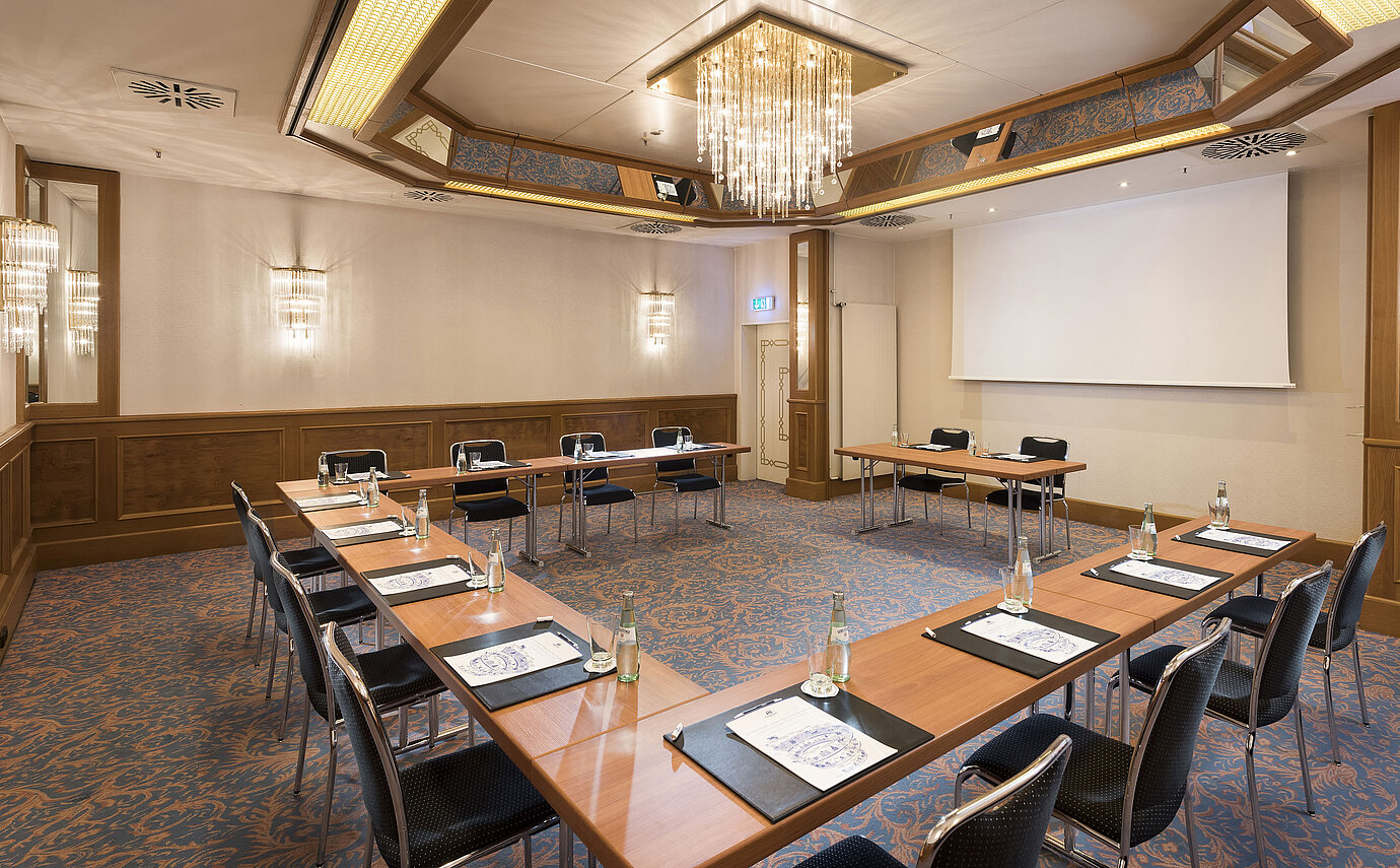 Bright conference room with U-shape seating and chandelier at the Maritim Hotel Munich