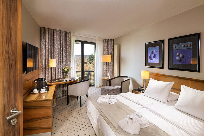 Comfort room at Maritim Hotel Bad Homburg with balcony, bright design, and cozy seating area.