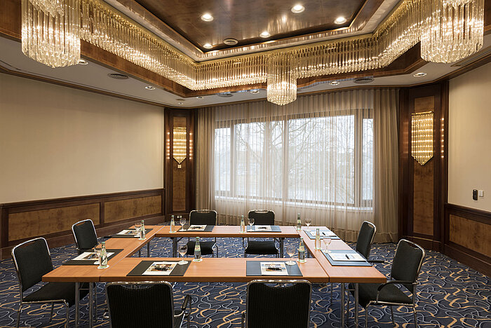 Small conference room with U-shape seating, daylight and chandeliers at Maritim Hotel Ulm.