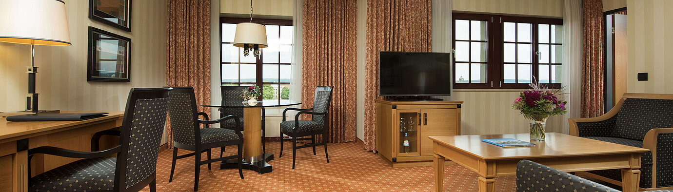 Junior Suite at Maritim Hotel Dresden with stylish seating area, large desk, and modern design.