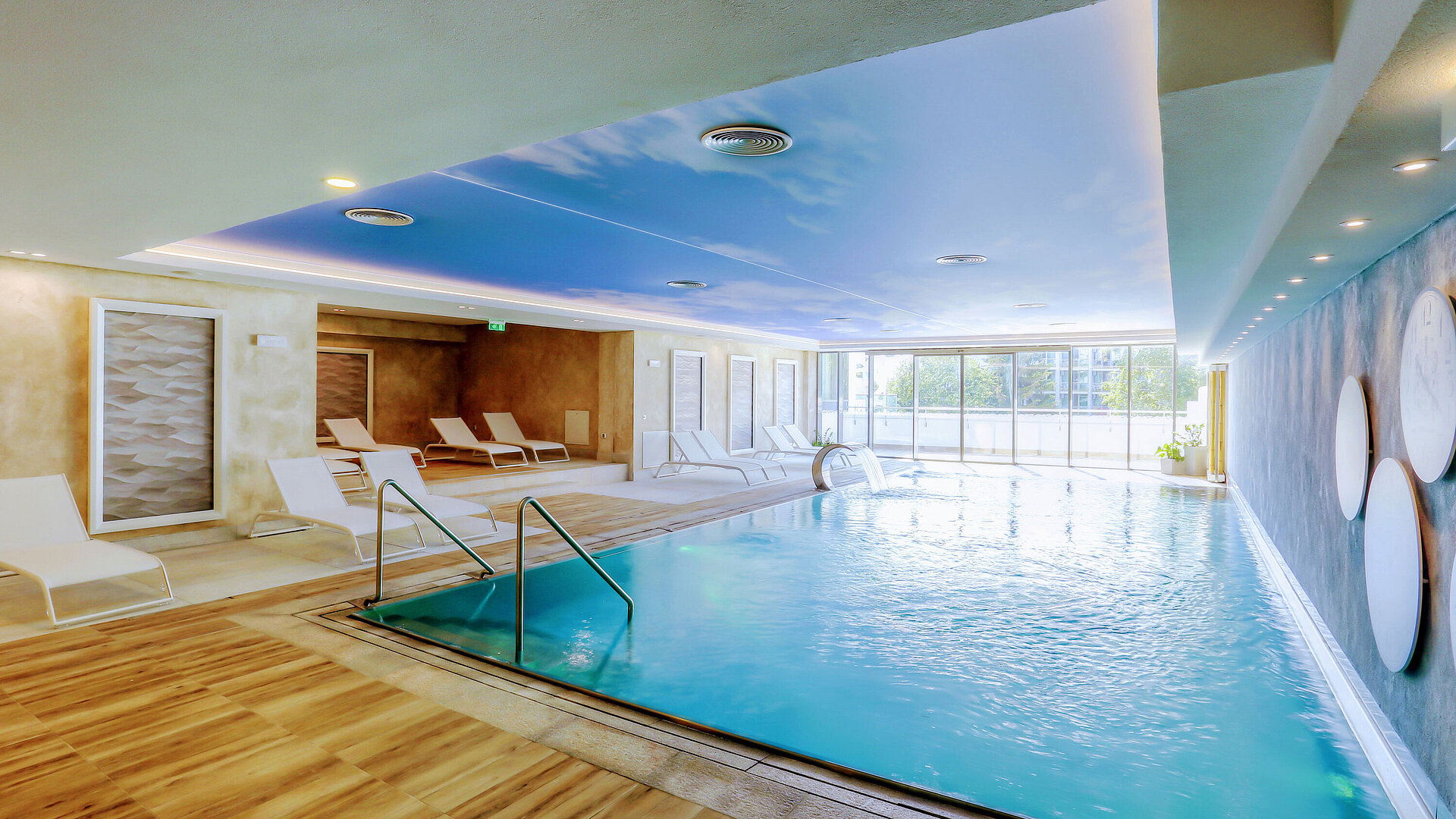 Bright indoor pool at the Maritim Hotel with modern loungers, large windows and a relaxing wellness atmosphere