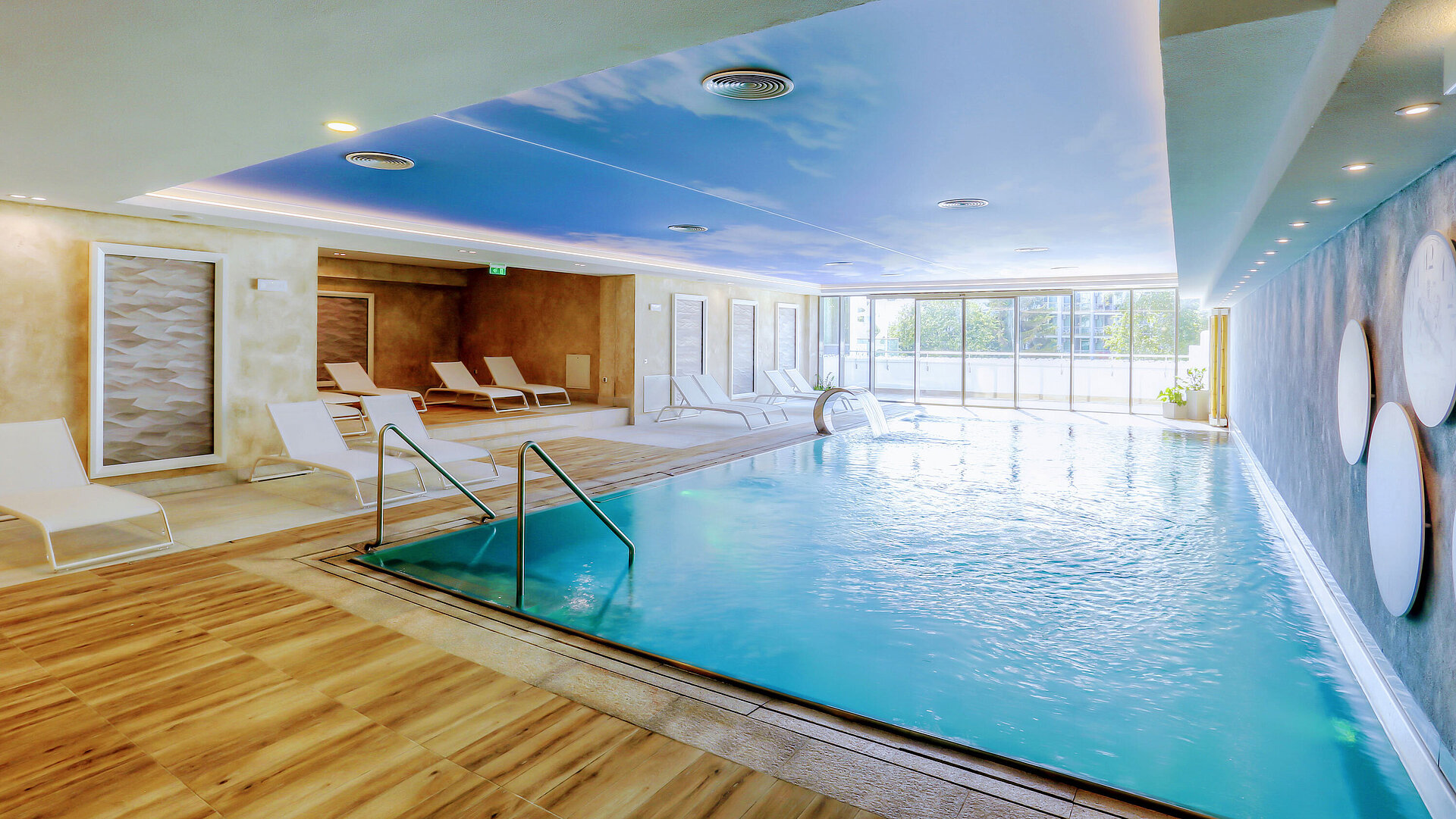 Bright indoor pool at the Maritim Hotel with modern loungers, large windows and a relaxing wellness atmosphere