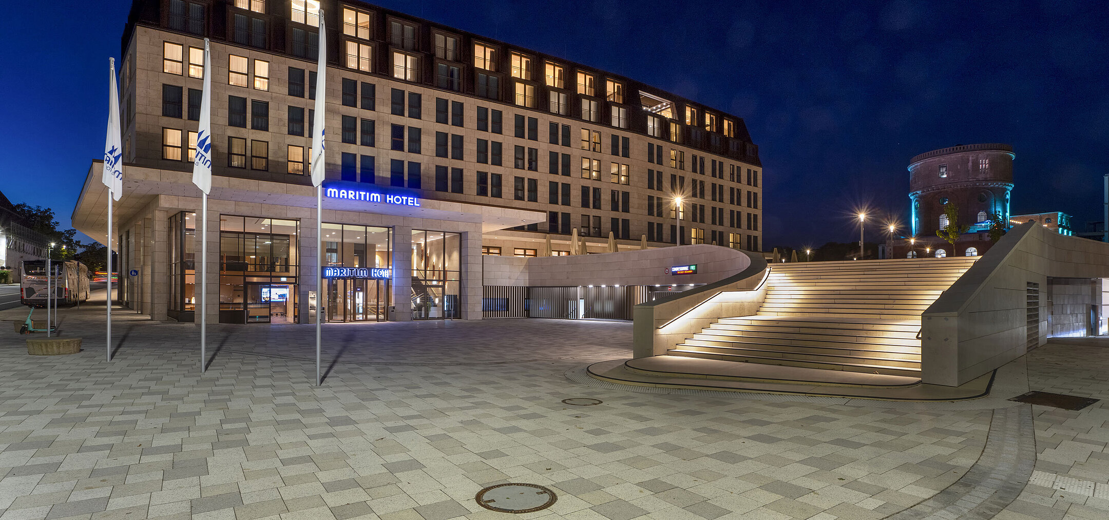 Entrance area of Maritim Hotel Ingolstadt at night with atmospheric lighting and staircase.