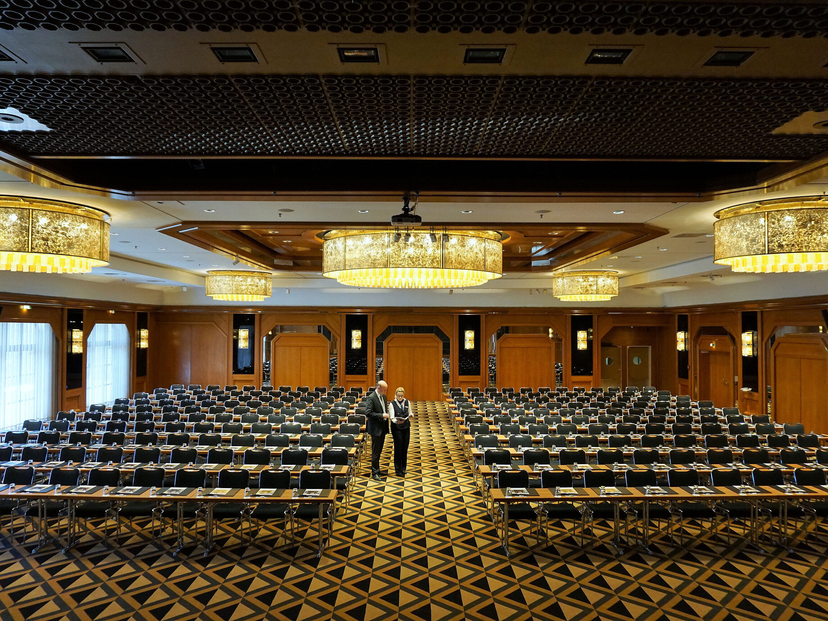 Elegant conference hall at Maritim Hotel Königswinter with modern seating and impressive chandeliers.