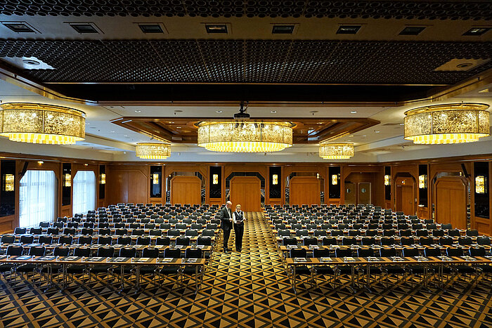 Elegant conference hall at Maritim Hotel Königswinter with modern seating and impressive chandeliers.