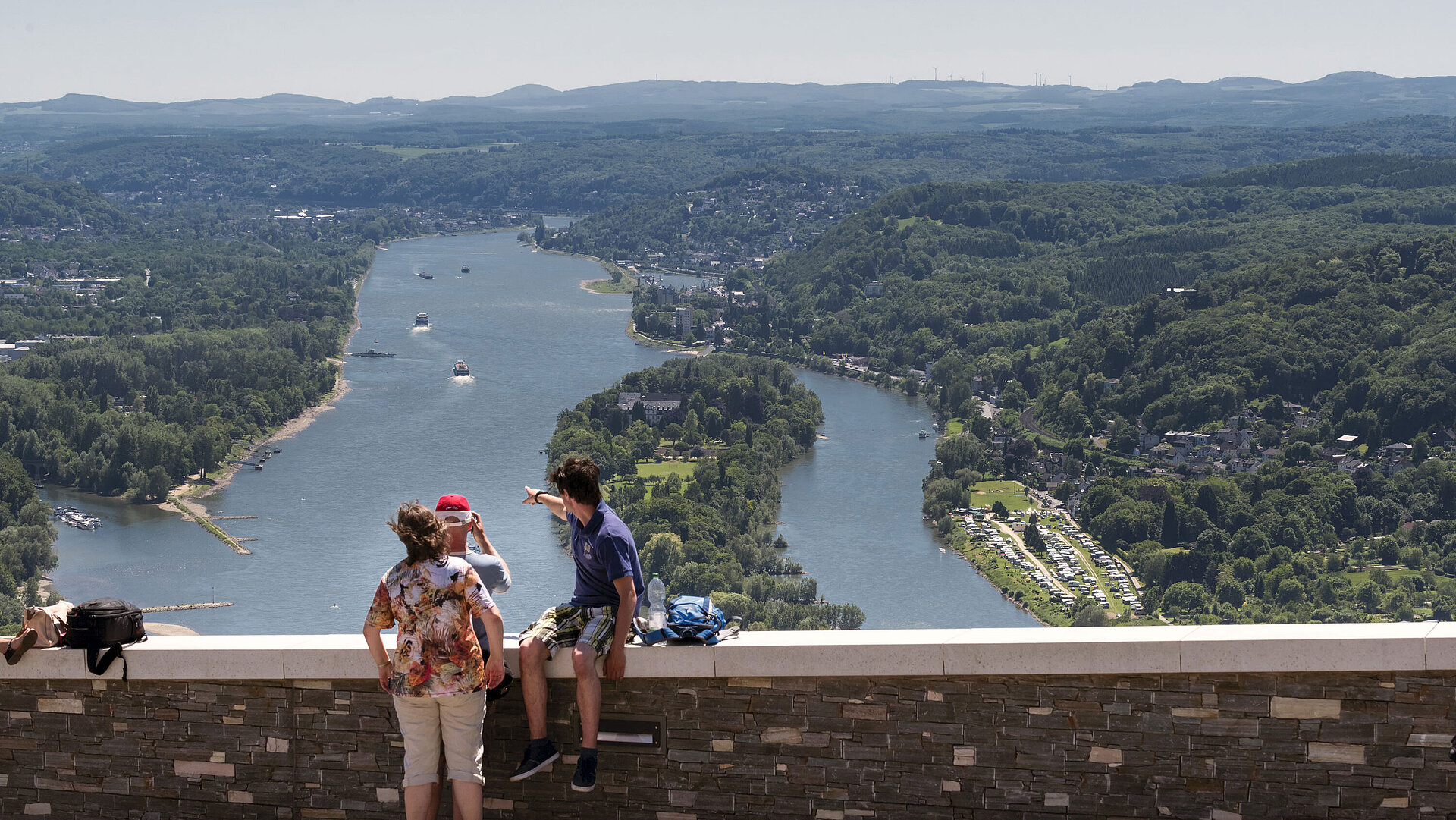 Visitors enjoy the breathtaking view from Drachenfels over the Rhine and surrounding forests.