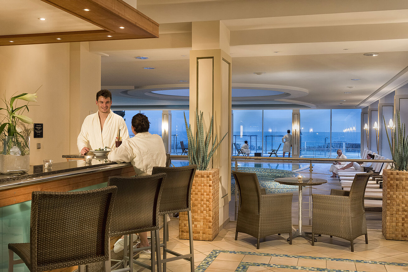 Spa area with pool and guests in bathrobes at Maritim Seehotel Timmendorfer Strand.