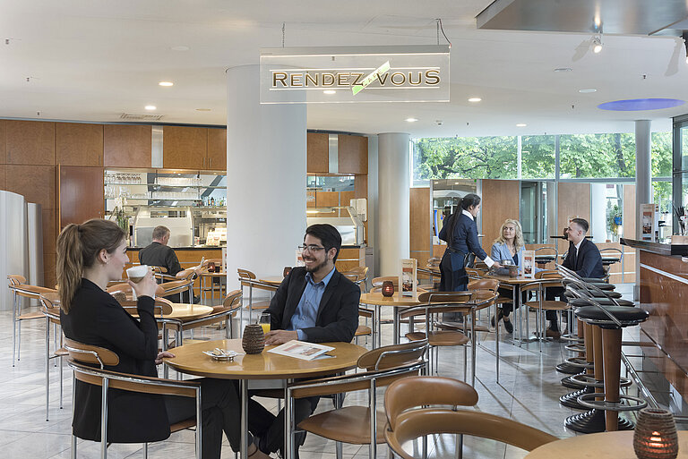 The Café Rendezvous at Maritim Hotel Frankfurt with guests enjoying coffee and friendly staff providing service.
