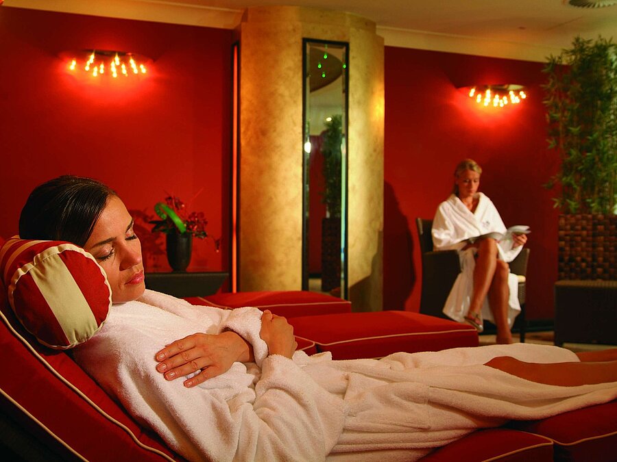 Relaxation loungers in the wellness area of Maritim Seehotel Timmendorfer Strand, with two women in bathrobes.